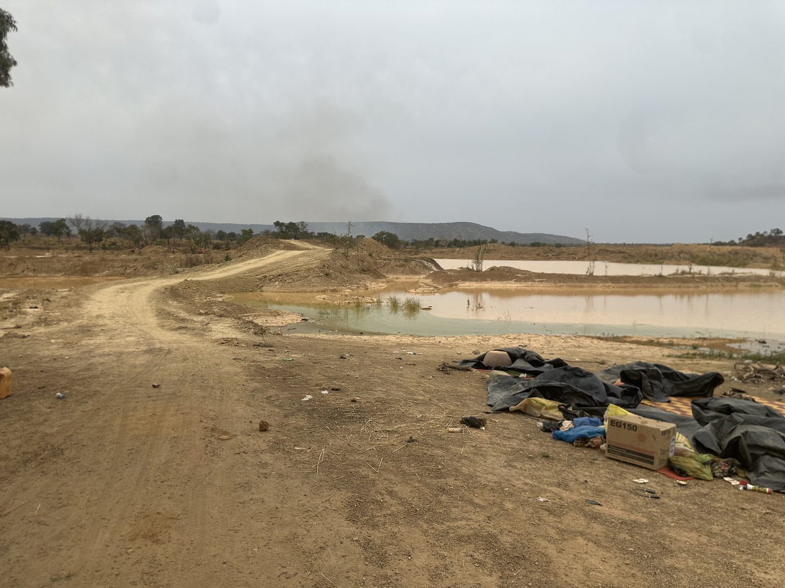 Site minier abandonné avec accumulation de déchets près d'un point d'eau